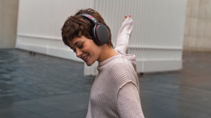 woman dancing while wearing a black pair of Sennheiser headphones